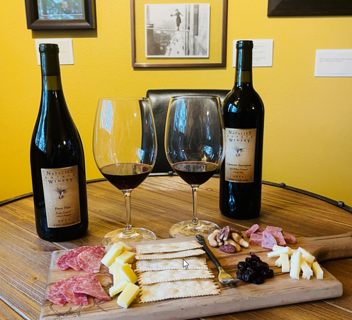 Bottles of Natalie's Estate cool climate Pinot Noir and warm climate Cabernet Sauvignon next to a charcuterie plate