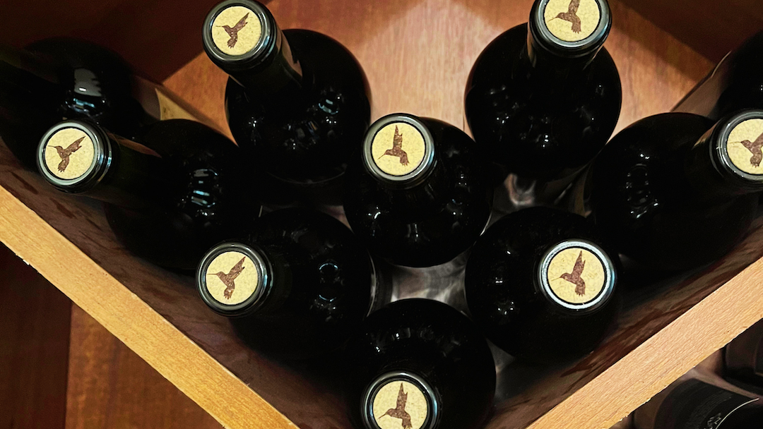 Wine bottles lying on a shelf.